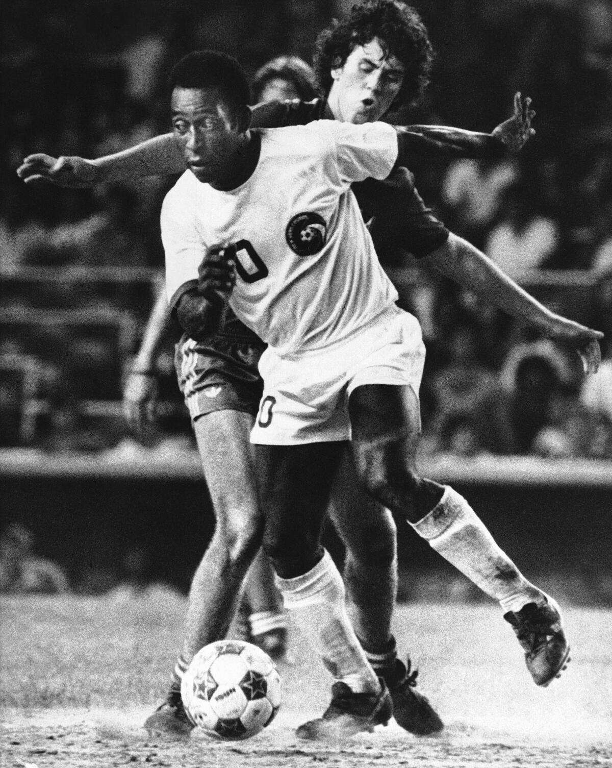 New York Cosmos forward Pelé, foreground, controls the ball during a match in August 1976.
