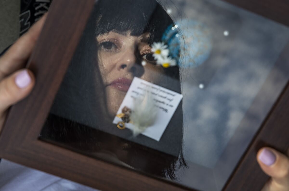 A woman is reflected in a shadow box.
