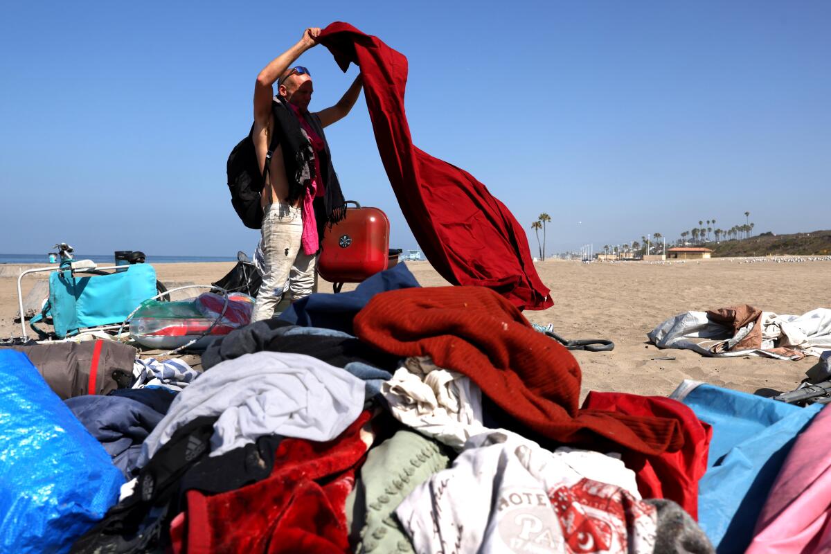 A homeless person gathering his belongings on Dockweiler State Beach