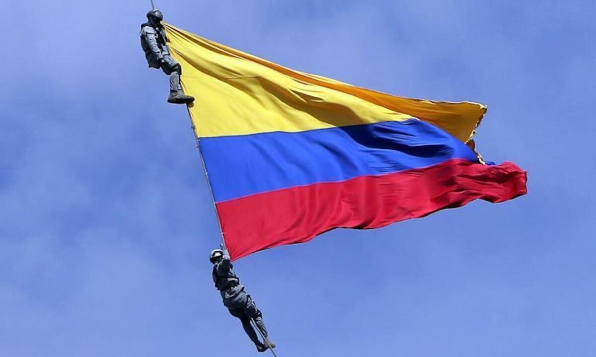 Dos soldados de la fuerza aérea de Colombia cuelgan de un helicóptero con una bandera colombiana durante la 'Feria de las Flores' en Medellín. Ambos fallecieron al reventarse el cable.