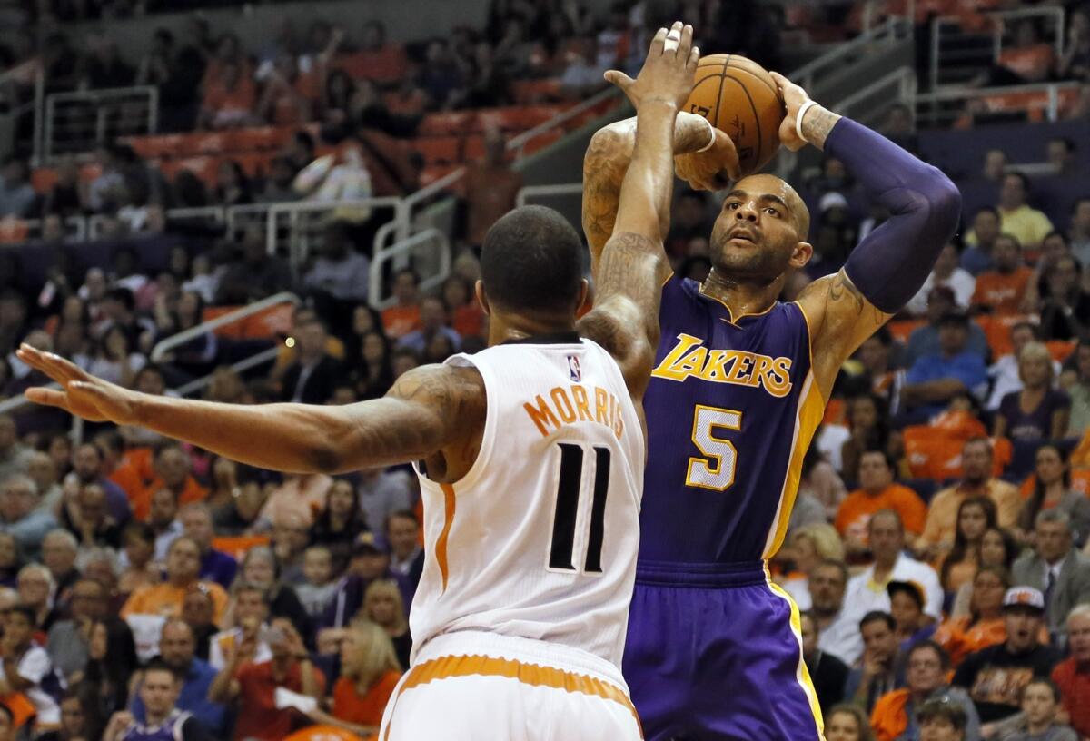 Lakers power forward Carlos Boozer pulls up for a shot over Suns forward Markieff Morris in the first half.