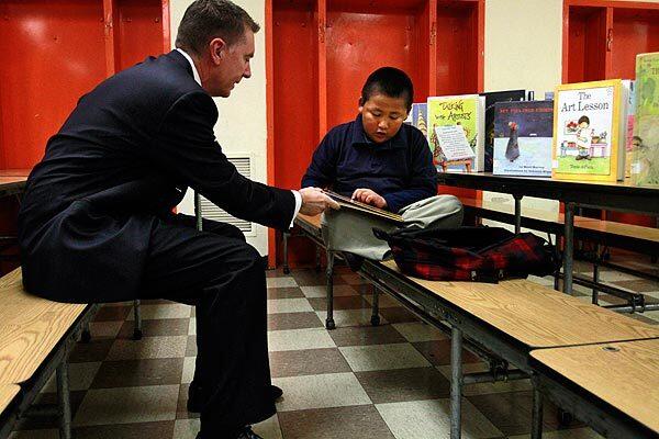 Los Angeles Unified School District Supt. John Deasy chats about a book that David Paredes is reading at Figueroa Street Elementary School in South L.A.