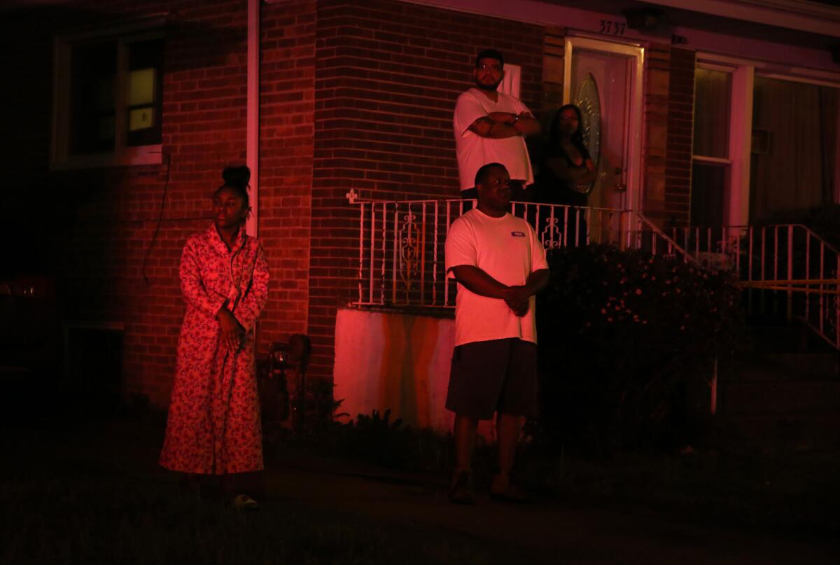 Neighbors watch as police investigate a shooting in their Ashburn neighborhood.