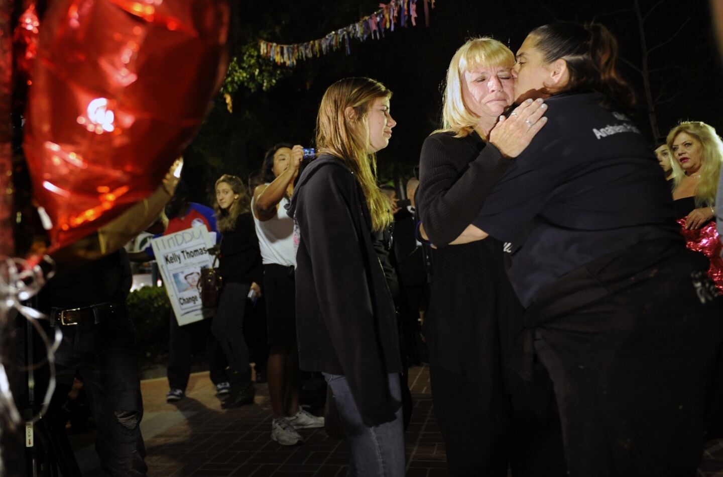 Kathy Thomas, mother of Kelly Thomas, receives a hug from a supporter in front of a memorial at "Kelly's Corner."