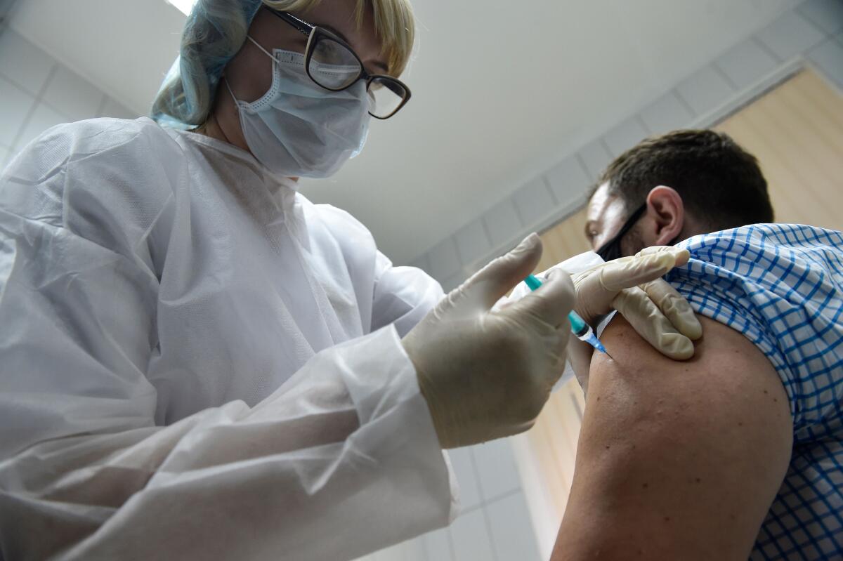 A nurse inoculates volunteer Ilya Dubrovin, 36, with Russia's new coronavirus vaccine in a trial in Moscow named 'Sputnik V'