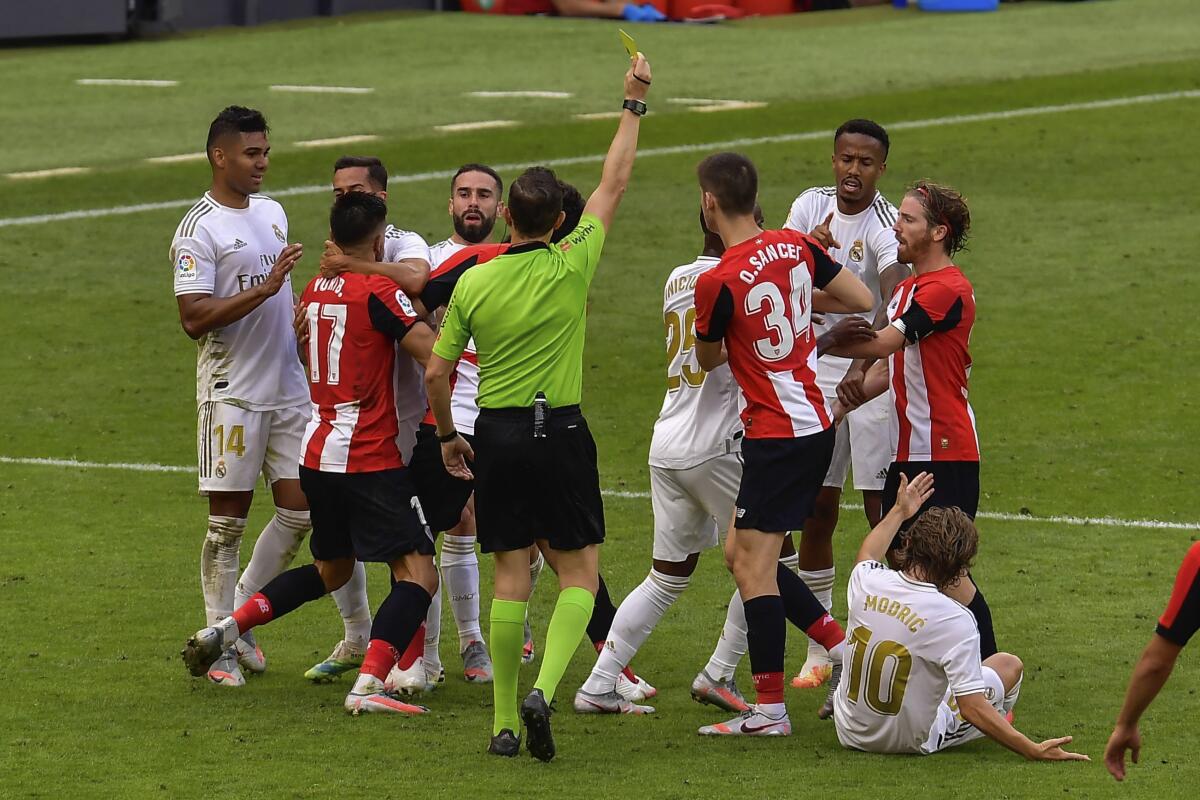 Jugadores del Athletic Bilbao y Real Madrid forcejean durante el partido de la Liga de España en Bilbao
