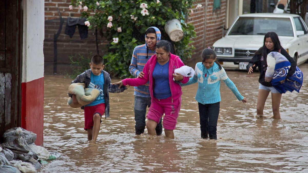 Residentes de Zoatlán, Nayarit, México, salen de sus hogares tras el paso del huracán Patricia.