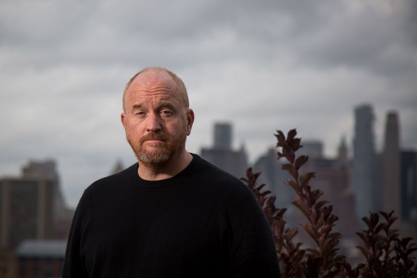 Louis CK poses for a portrait in front of a city skyline