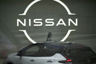 ARCHIVO - Una persona pasa junto a un logo de Nissan en la sede de la automotriz, el 12 de mayo de 2022 en Yokohama, cerca de Tokio. (AP Foto/Eugene Hoshiko, Archivo)