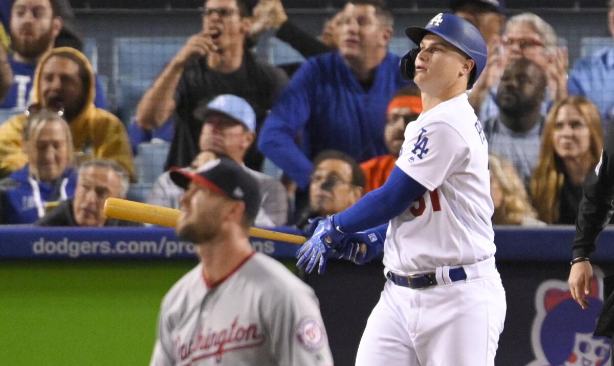 Joc Pederson tracks the ball after hitting a home run. Washington pitcher Hunter Strickland is in the foreground.
