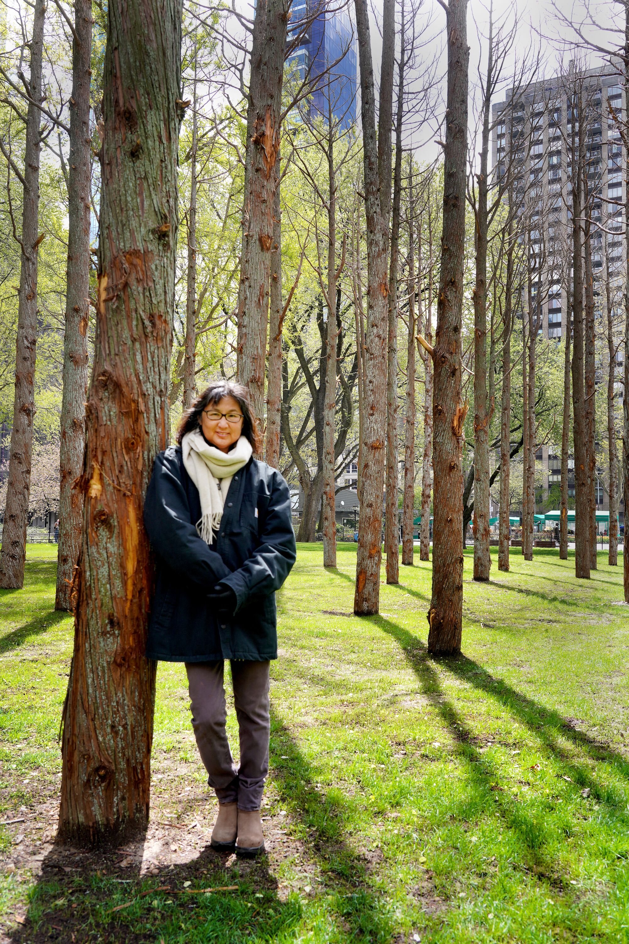 Maya Lin leans against one of the Atlantic cedars featured in her installation.