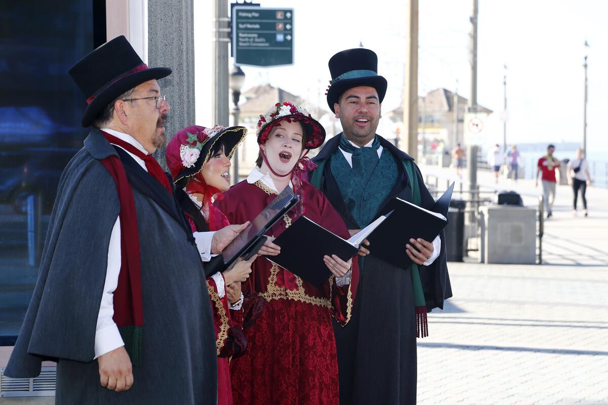Christmas carolers sing holiday songs during Wednesday's soft opening for the Surf City Winter Wonderland ice skating rink.