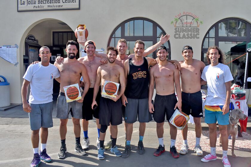 Team members from Crushin’ Dreams, 2018 winners of the inaugural Summer Classic, are presented with Sneaks-branded basketballs by tournament co-founders Sawsun Khodapanah and Tyson Young at La Jolla Rec Center.