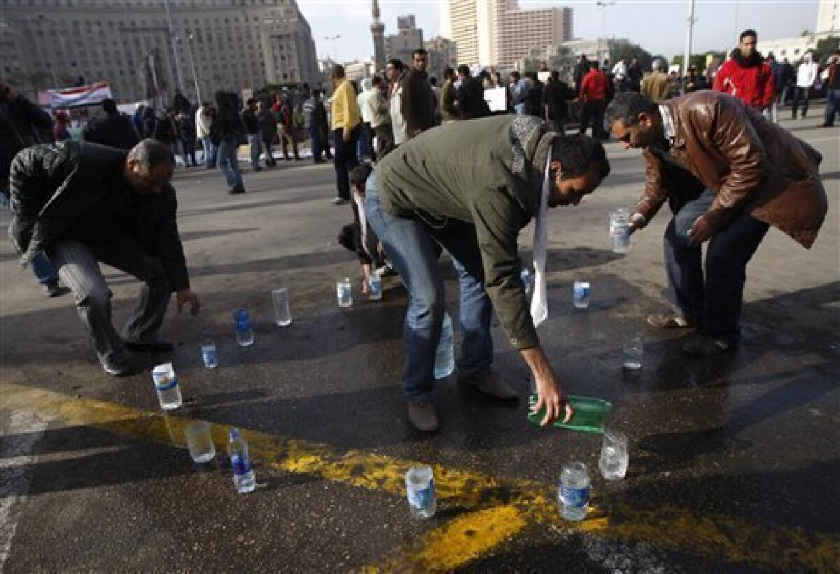 A man fills up containers with water that he offers to demonstrators in Tahrir, or Liberation, Square in Cairo, Egypt, Tuesday, Feb. 1, 2011. Security officials say authorities have shut down all roads and public transportation to Cairo, where tens of thousands of people are converging to demand the ouster of Egyptian President Hosni Mubarak after nearly 30 years in power. (AP Photo/Khalil Hamra)