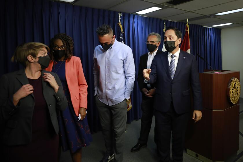 SAN DIEGO, CA - NOVEMBER 29: San Diego Mayor Todd Gloria, right, surrounded by city council members, leaves a news conference after the council voted to move forward with vaccinate mandates on Monday, Nov. 29, 2021. (K.C. Alfred / The San Diego Union-Tribune)