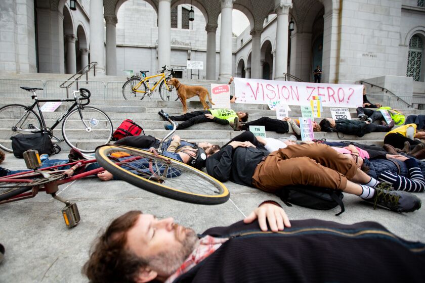 Los Angeles, CA., December 3, 2019: Traffic safety advocates hold a "die-in" on the steps of L.A. City Hall on Tuesday December, 3, 2019. to protest the city's lack of progress on Vision Zero, a program created by Mayor Eric Garcetti in 2015 that aims to eliminate traffic deaths on city streets by 2025.(Jason Armond / Los Angeles Times)
