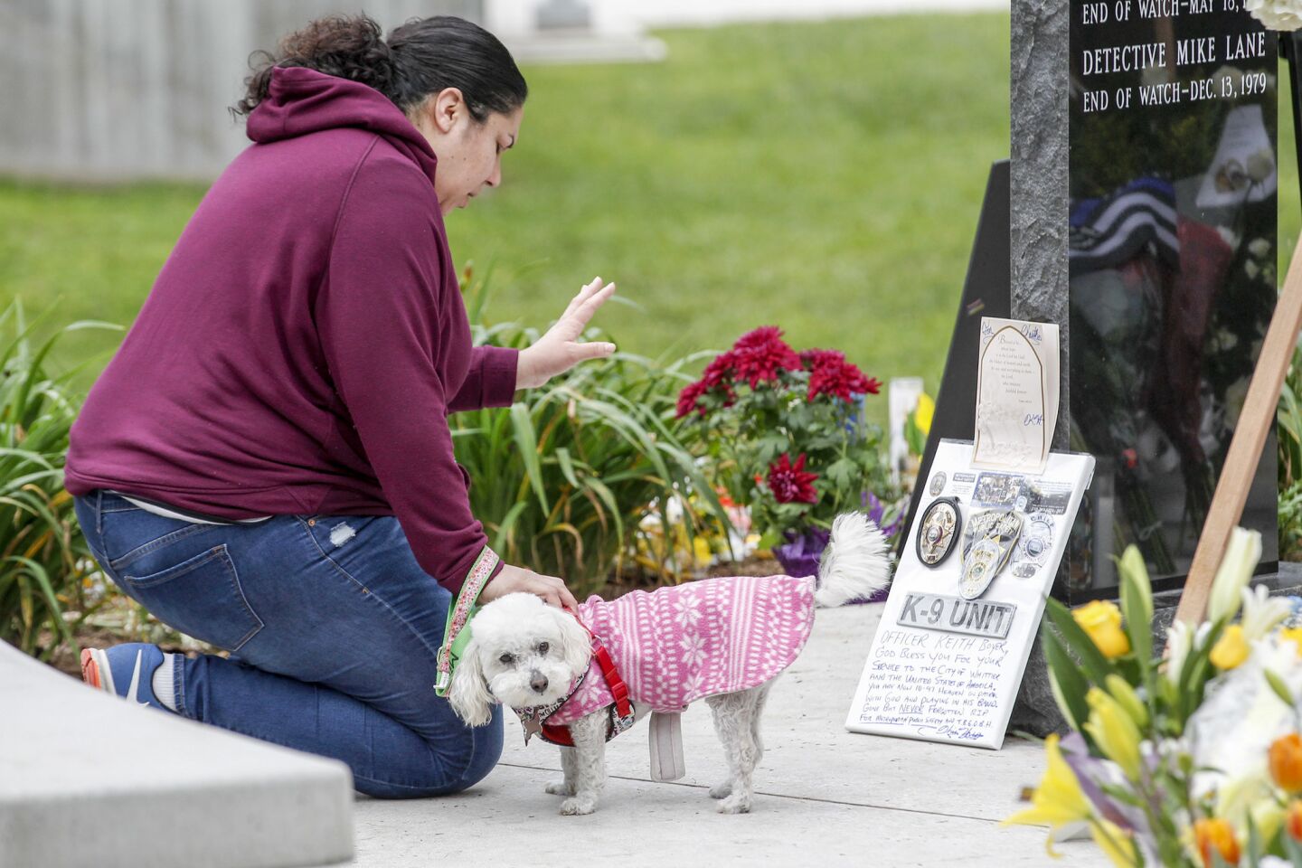 Abisai Espinales, with her dog, Mila, stops to pray at the make shift memorial for slain Whittier police officer Keith Boyer in front of police station.
