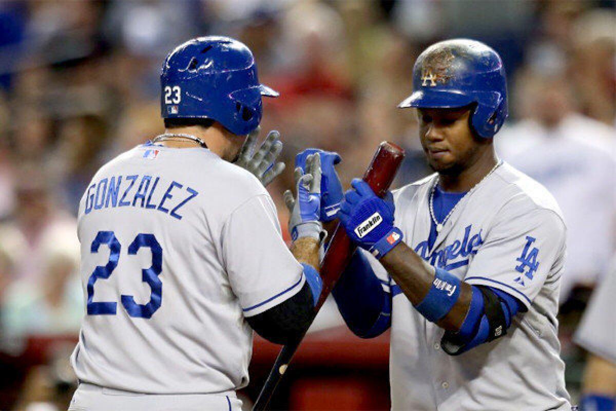 Adrian Gonzalez celebrates with Hanley Ranirez after hitting a solo home run during the Dodgers' 14 inning victory over the Arizona Diamondbacks, 7-5.