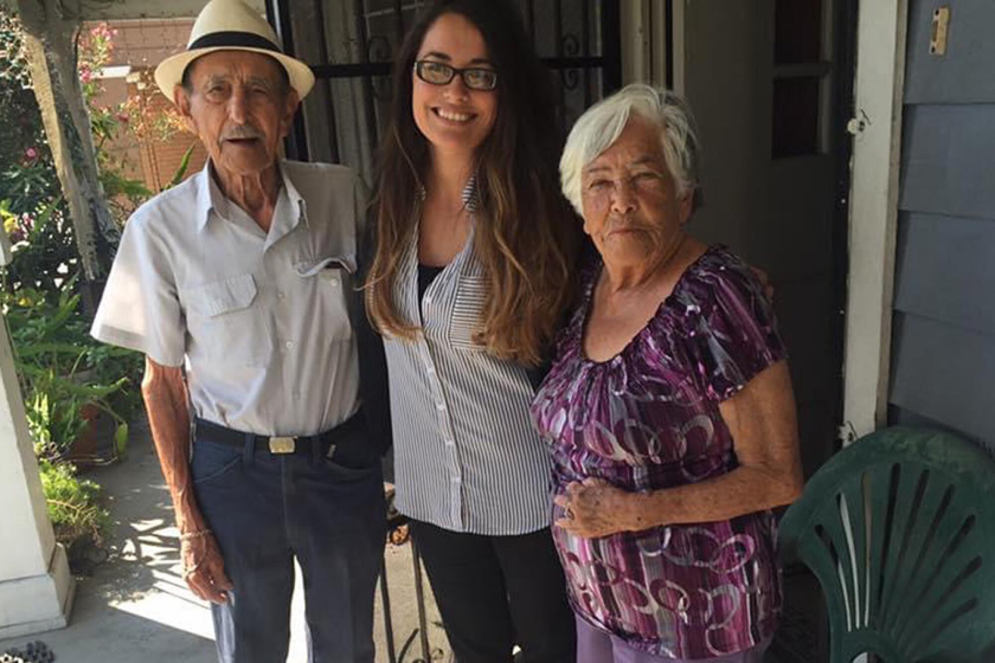 Brittny Mejia with her grandfather and grandmother, Maria Diaz, on her front porch in Highland Park.