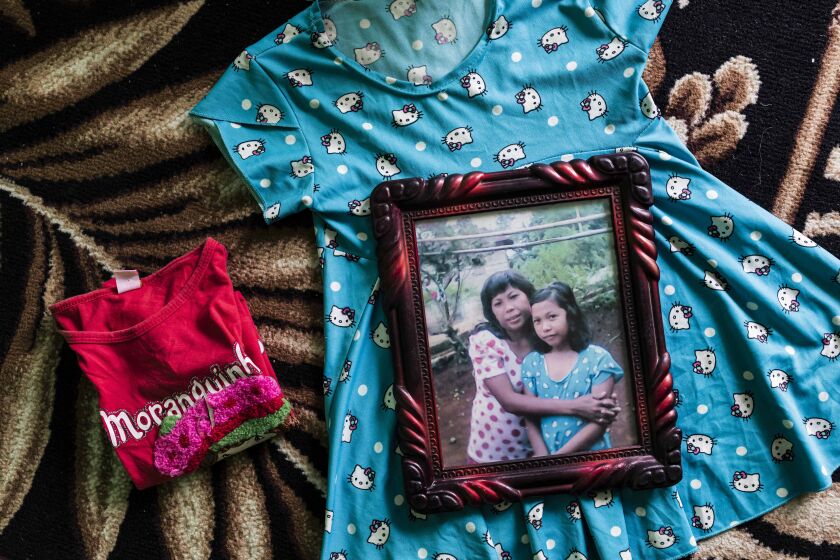 Yuyun's mother keeps her daughter's favorite clothes at home in Bengkulu, Indonesia on Wednesday, May 26, 2021. Yuyun was wearing the dress in the last picture that they look together. Irene Barlian for Los Angeles Times.