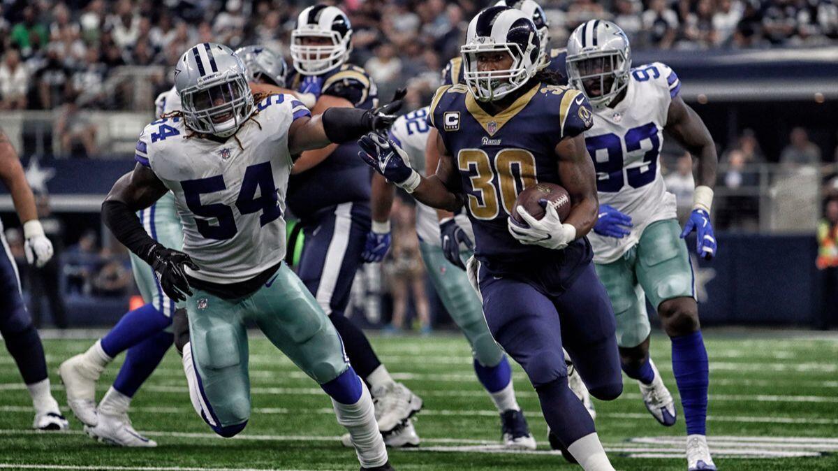 Rams running back Todd Gurley runs past Cowboys defenders during third quarter action on Sunday.