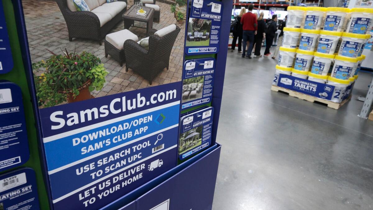 A sign encourages shoppers to use a Sam's Club phone app.
