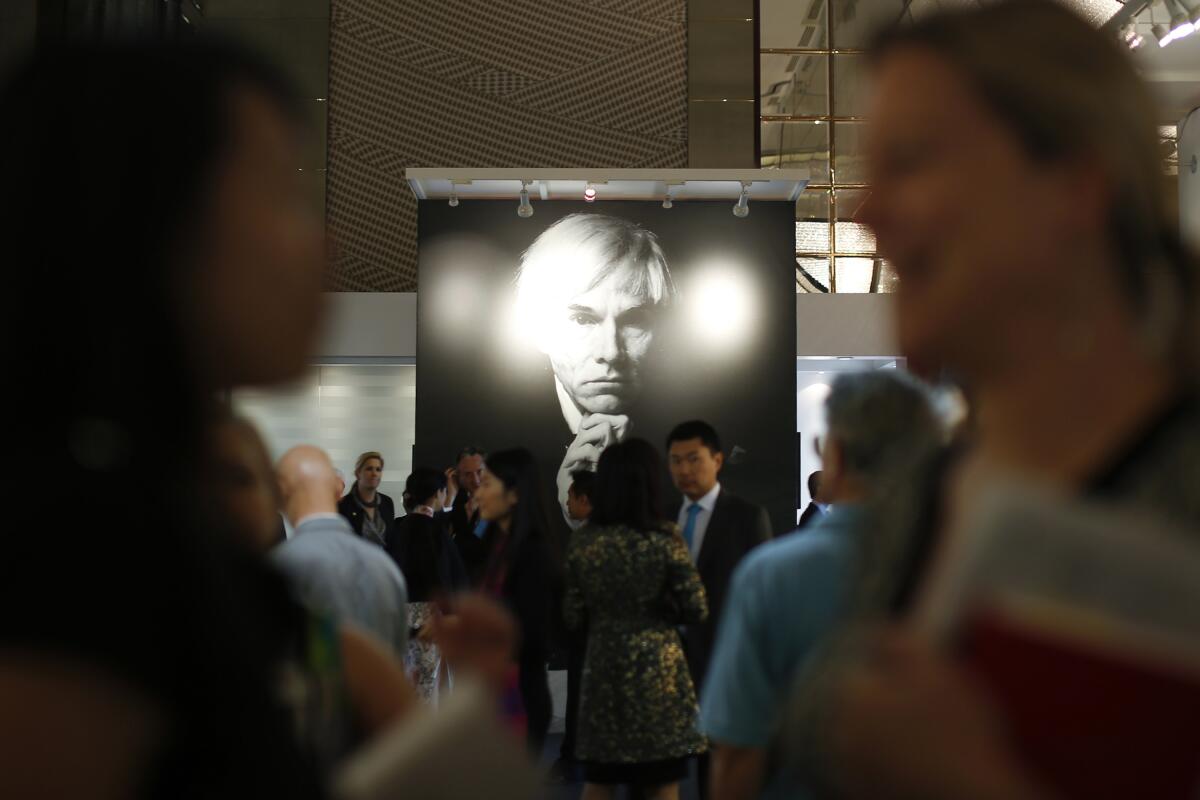 2013 photo of people in front of a poster of Andy Warhol in a gallery