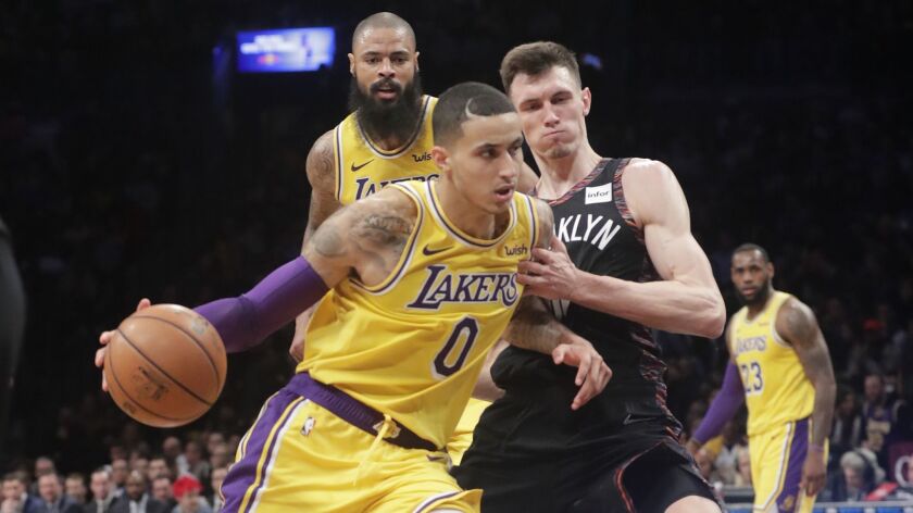 Lakers' Kyle Kuzma (0) drives past Brooklyn Nets' Rodions Kurucs (00) during the first half on Dec. 18, 2018, in New York.