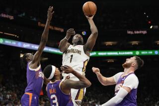 Zion Williamson (1), de los Pelicans de Nueva Orleans, dispara entre tres jugadores de los Suns de Phoenix, Bol Bol, Bradley Beal (3) y Jusuf Nurkic (20), durante la primera mitad del juego de baloncesto de la NBA, el domingo 7 de abril de 2024, en Phoenix. (AP Foto/Rick Scuteri)