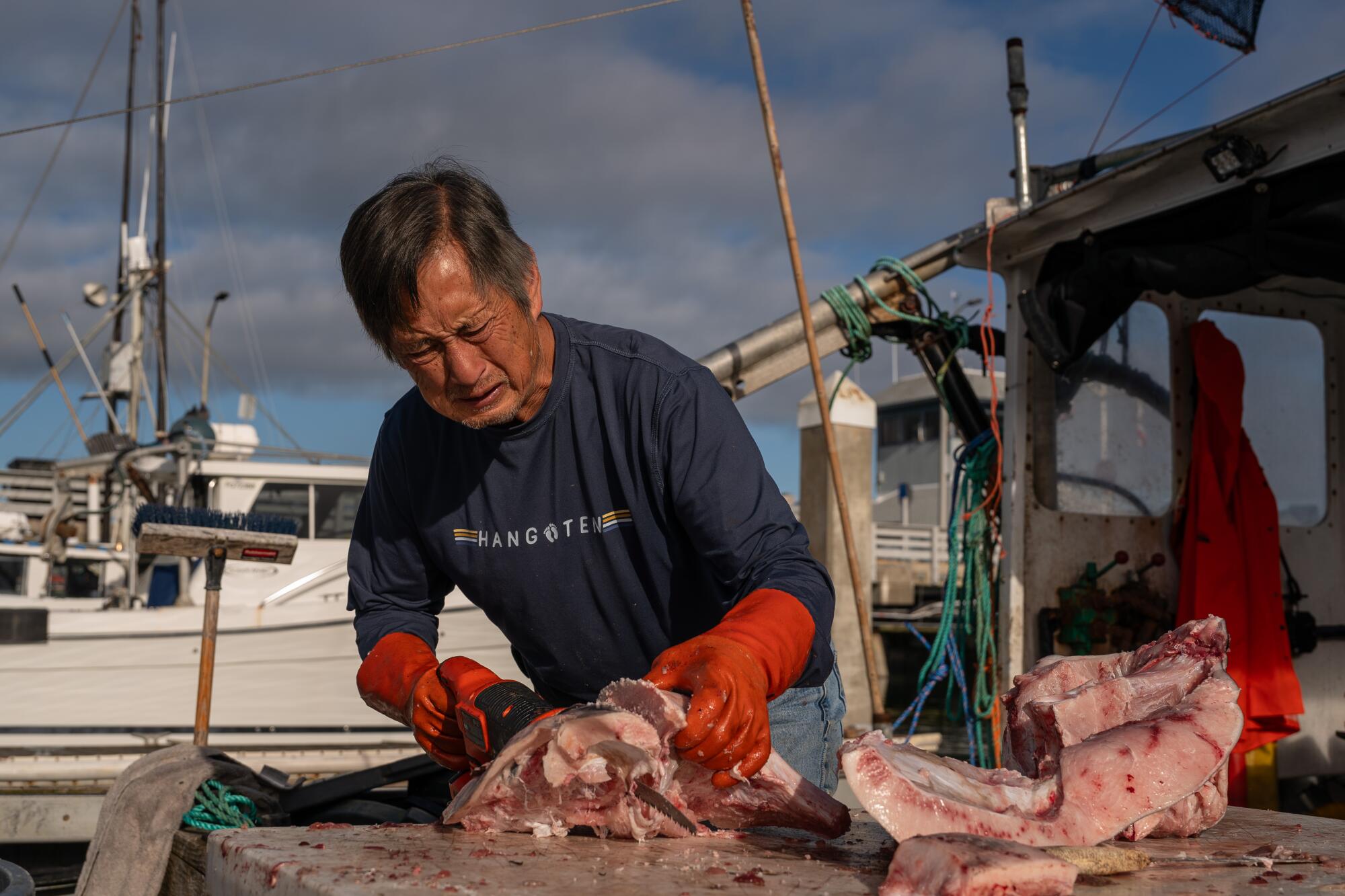 Commercial fisherman George Jue prepares swordfish scraps to use as crab fishing bait at Pillar Point Harbor.