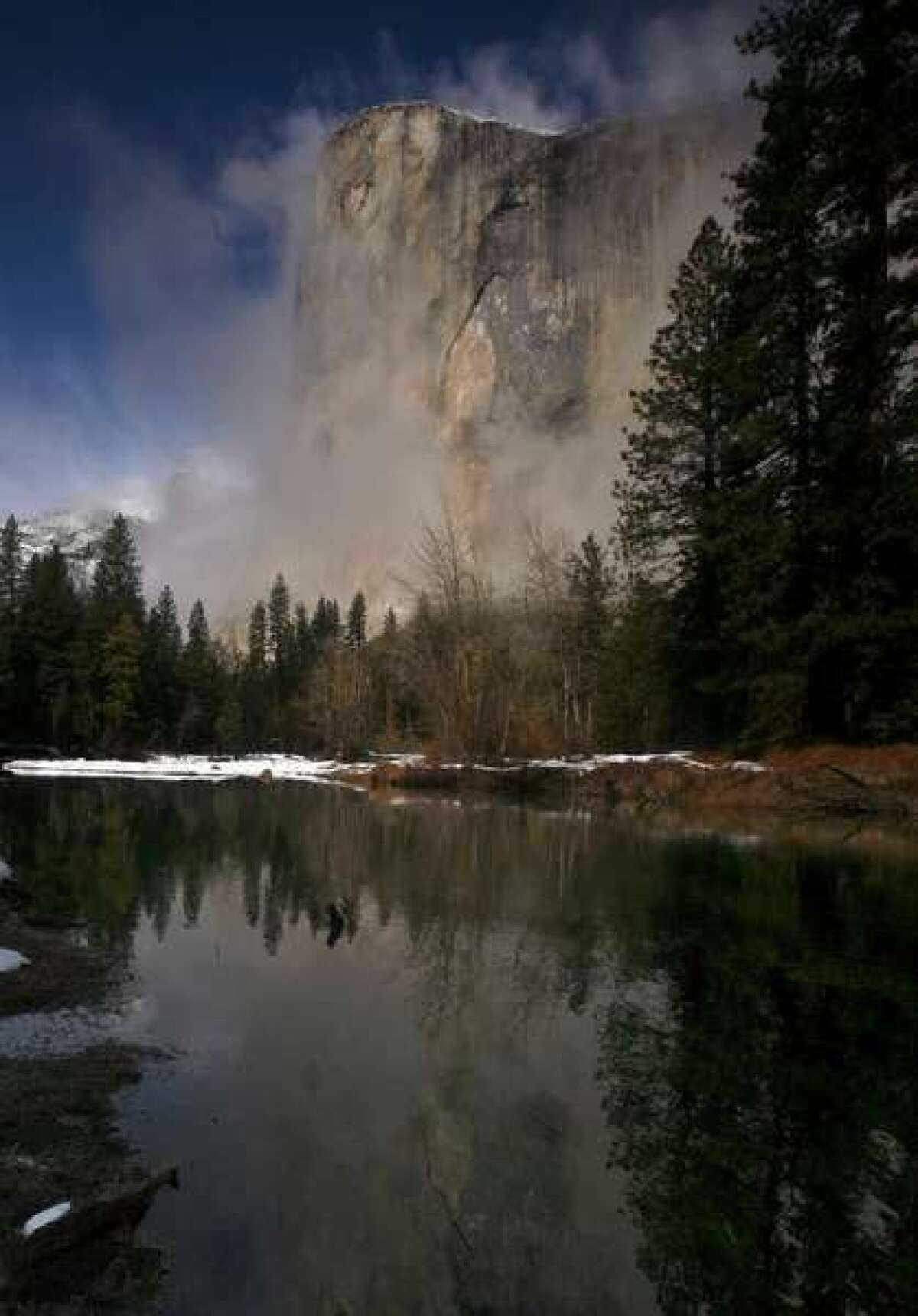 The iconic granite El Capitan is shrouded by fog on a winter day in Yosemite National Park.