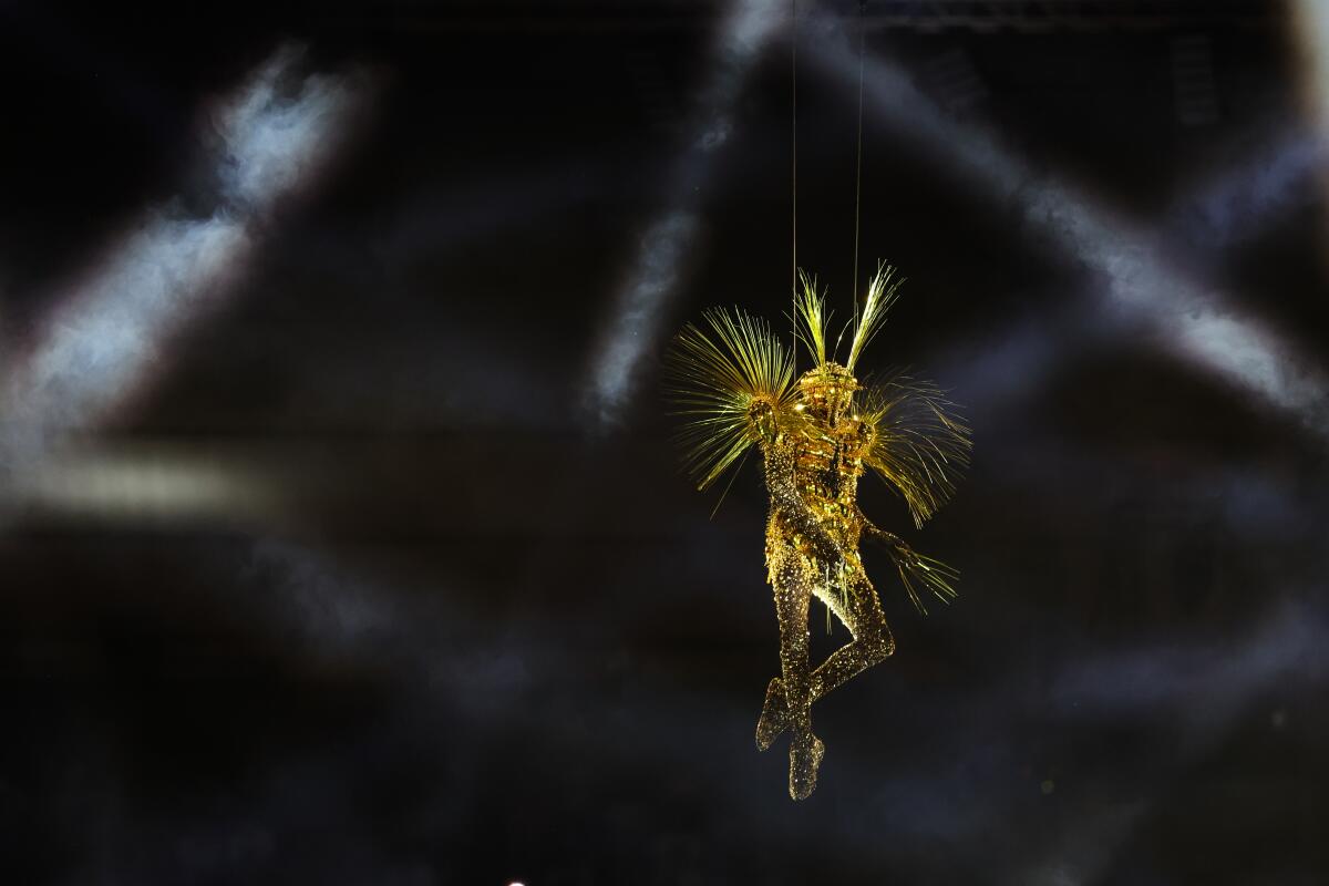  An artist repels down from the stadium roof during the closing ceremony of the 2024 Paris Olympics at Stade de France 