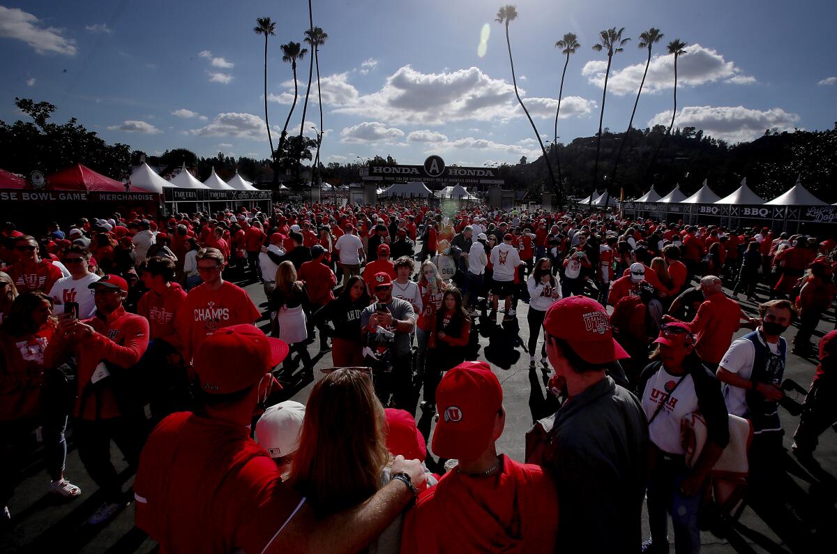 Utah and Ohio State football fans take photos in front of the Rose Bowl before the start of Saturday's game.