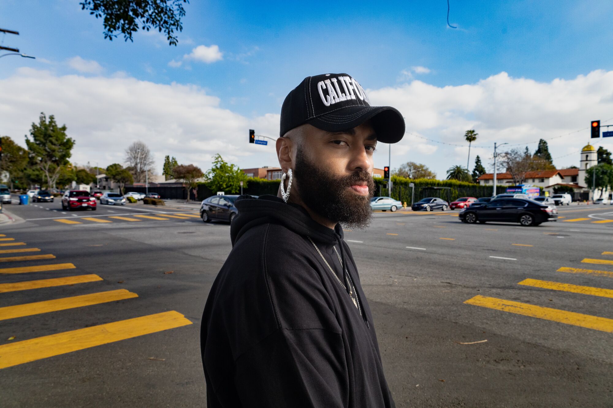 Davis looks at the camera wearing a black hat that says "California."