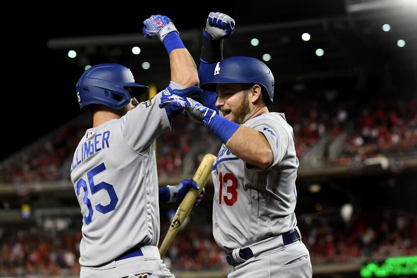 Wally Skalij  Los Angeles Times DODGERS BACK IN CONTROL Max Muncy and Cody Bellinger celebrate Muncy’s fifth-inning solo home run. A seven-run sixth inning carried Los Angeles to a 10-4 victory and 2-1 series lead over the Washington Nationals. SPORTS, D1