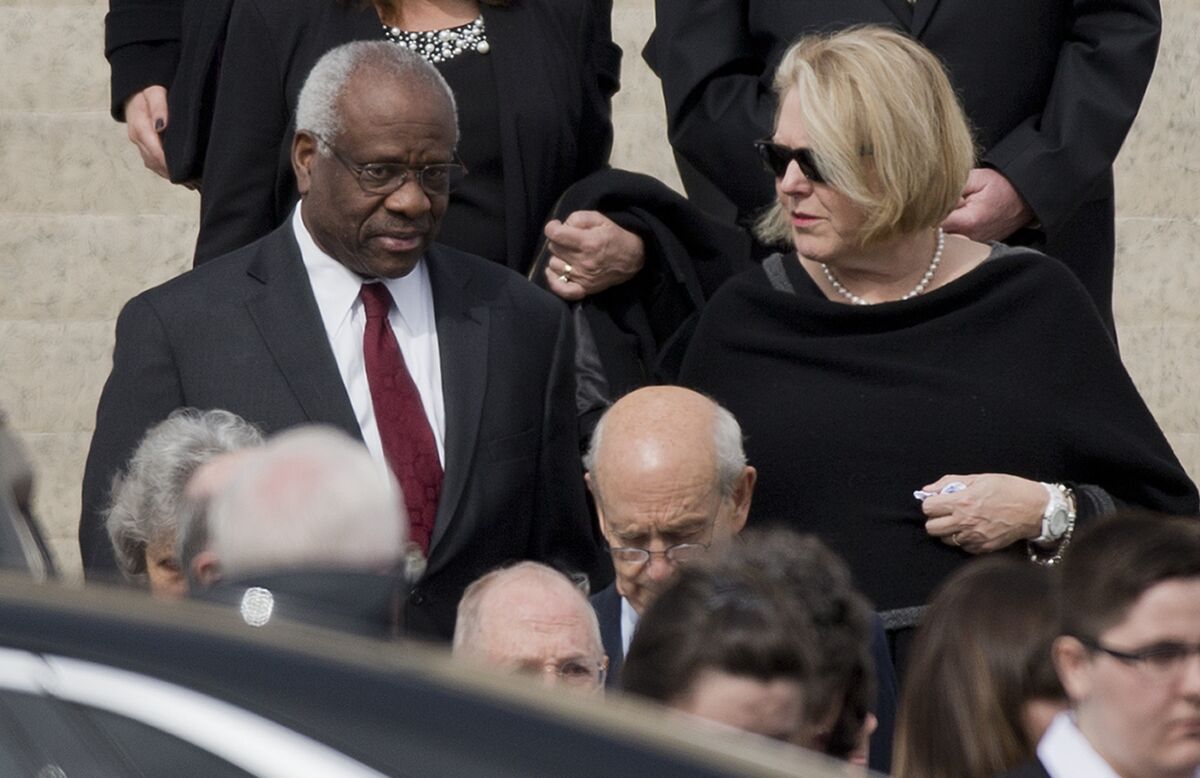 FILE - Supreme Court Associate Justice Clarence Thomas, left and his wife Virginia Thomas,.