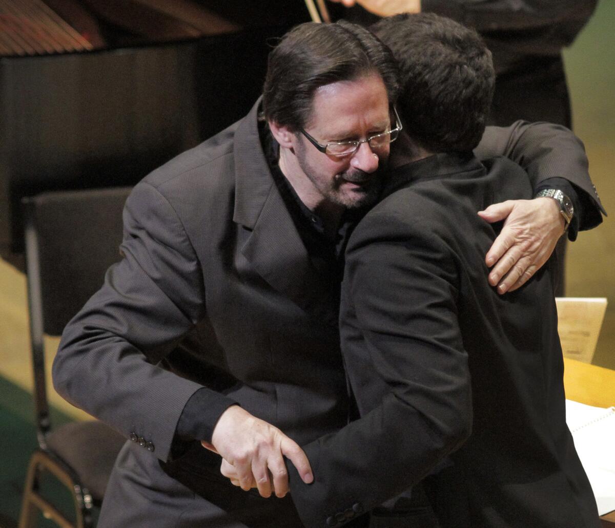 Steven Stucky, left, embraces conductor Lionel Bringuier during a 2012 concert at Walt Disney Concert Hall in Los Angeles.