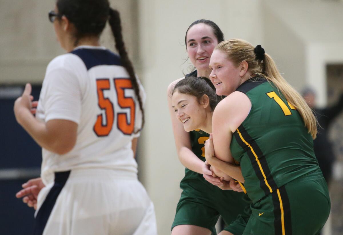 Edison's Taylor Fullbright and Lainey Johnson (14) hold up teammate Gwen Ontiveros after she made two critical free throws to put the game into overtime in the Larry Doyle and Dan Wiley Tournament of Champions at Marina High on Thursday.