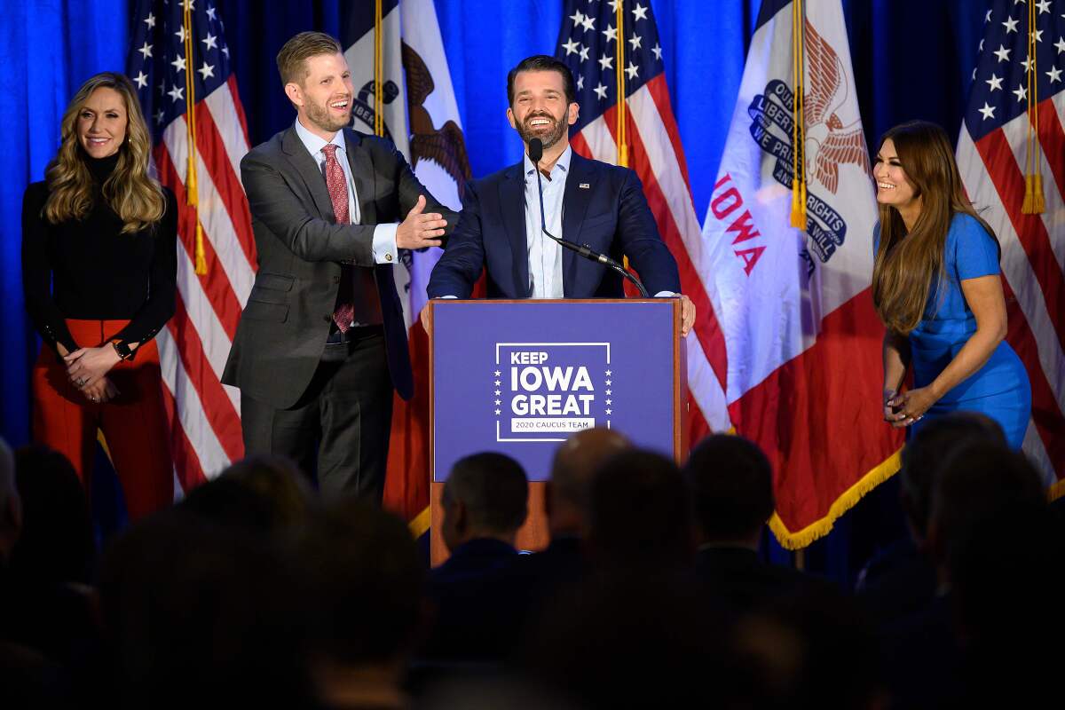 Donald Trump Jr., center, speaks with his brother Eric, left, during a "Keep Iowa Great" press conference in Des Moines, IA.