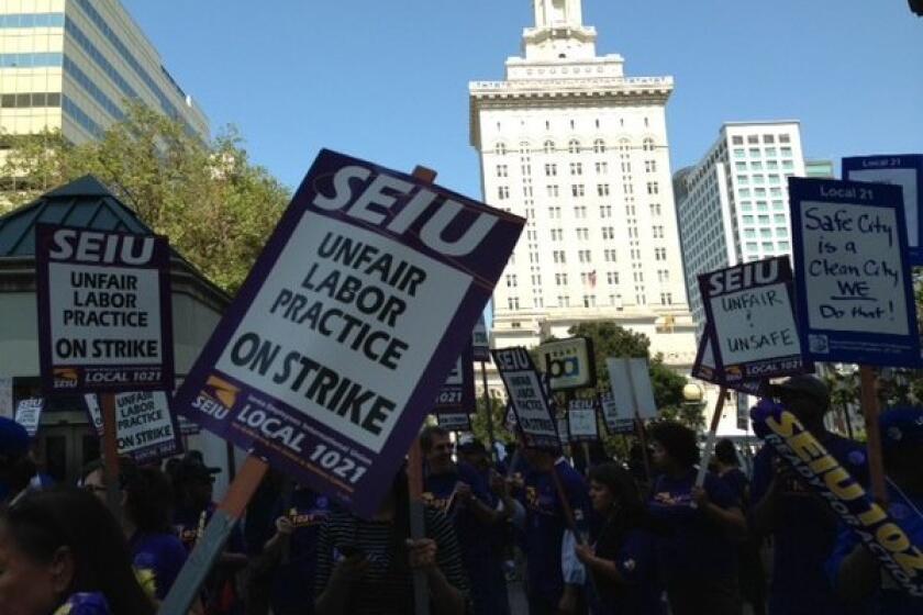 Union workers protest in front of Oakland City Hall.