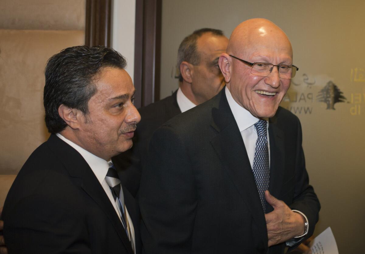 Newly designated Lebanese Prime Minister Tammam Salam, right, smiles after addressing the media to announce the formation of a new Lebanese government at the presidential palace in Baabda east of Beirut on Saturday.