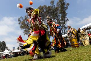 People dressed in regalia perform during the grand entry at the 35th powwow at Balboa Park on Saturday, May 13, 2023.