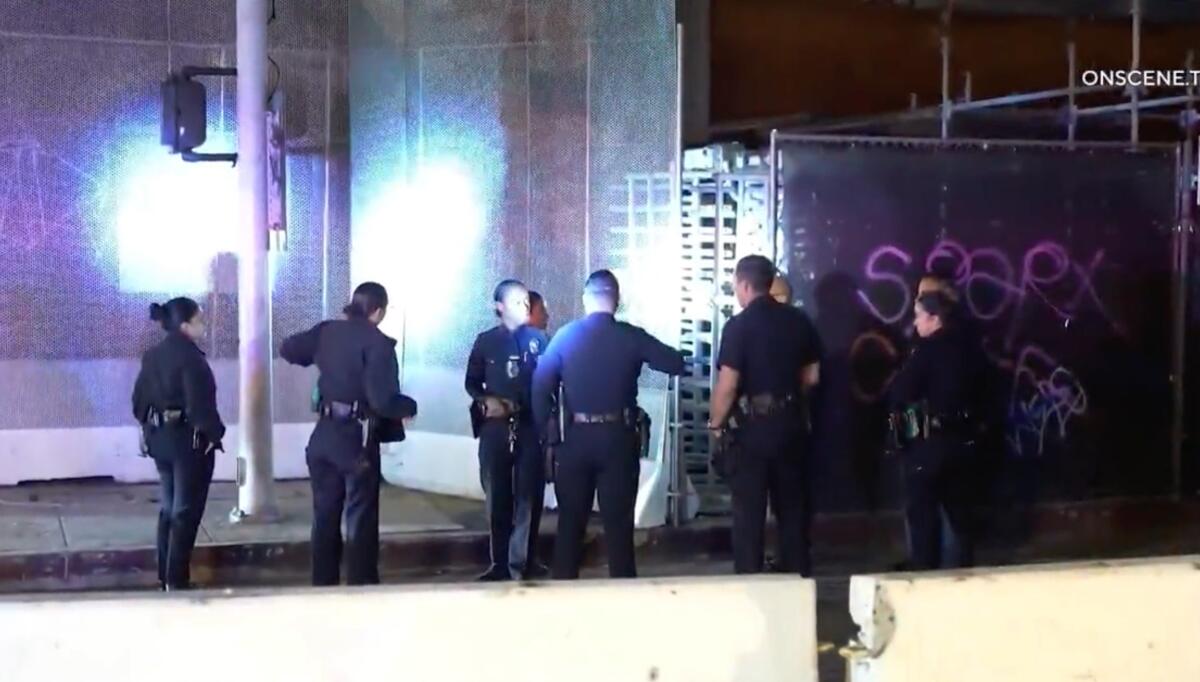 Los Angeles police on the grounds of the unfinished Oceanwide Plaza complex in the dark.