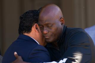 Michael Cooper, right, hugs a Pasadena Mayor Victor M. Gordo 