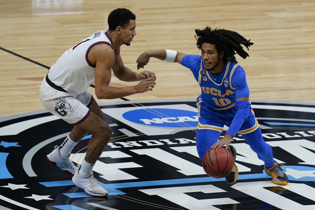 UCLA guard Tyger Campbell dribbles past Gonzaga guard Jalen Suggs 