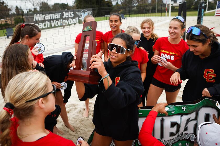 San Diego, CA - May 04: Cathedral Catholic's Maria Neves (7), center, holds the trophy as she and teammates celebrate beating Torrey Pines during the CIF San Diego Section beach volleyball Open Division championship at Miramar College on Saturday, May 4, 2024 in San Diego, CA. (Meg McLaughlin / The San Diego Union-Tribune)