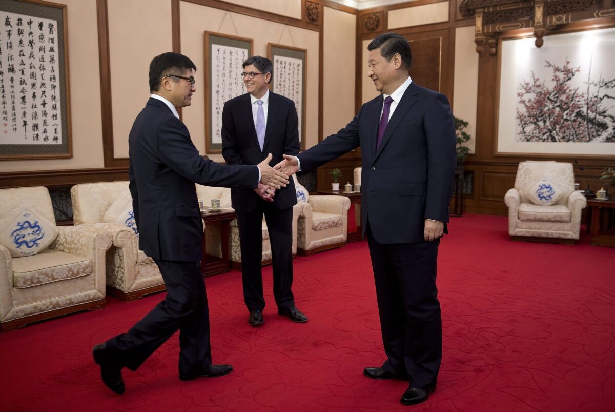 U.S. Ambassador to China Gary Locke, left, shakes hand with Chinese President Xi Jinping before they and U.S. Treasury Secretary Jacob Lew, center, meet at the Diaoyutai State Guesthouse in Beijing.