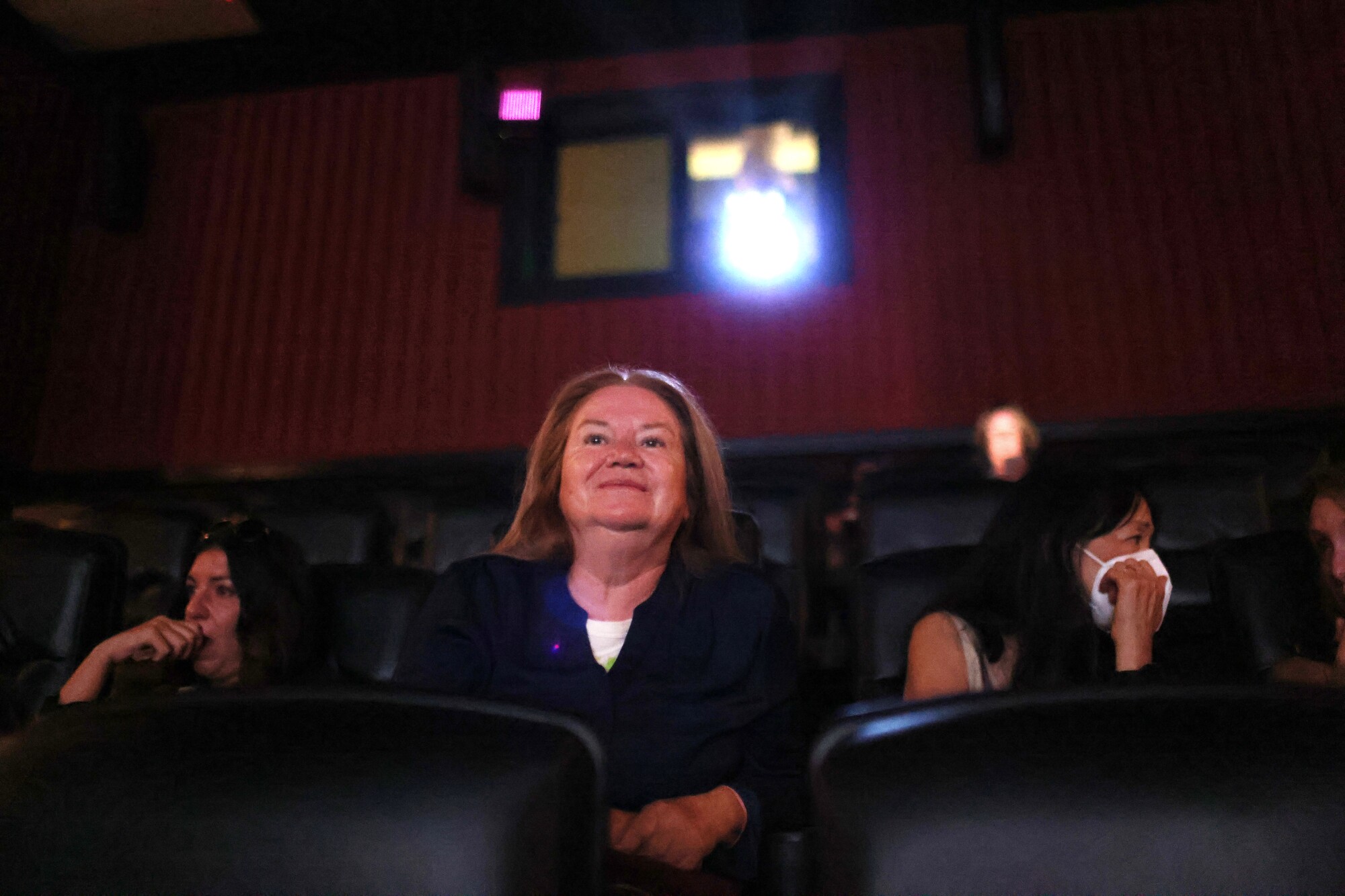 A woman smiles in a movie theater