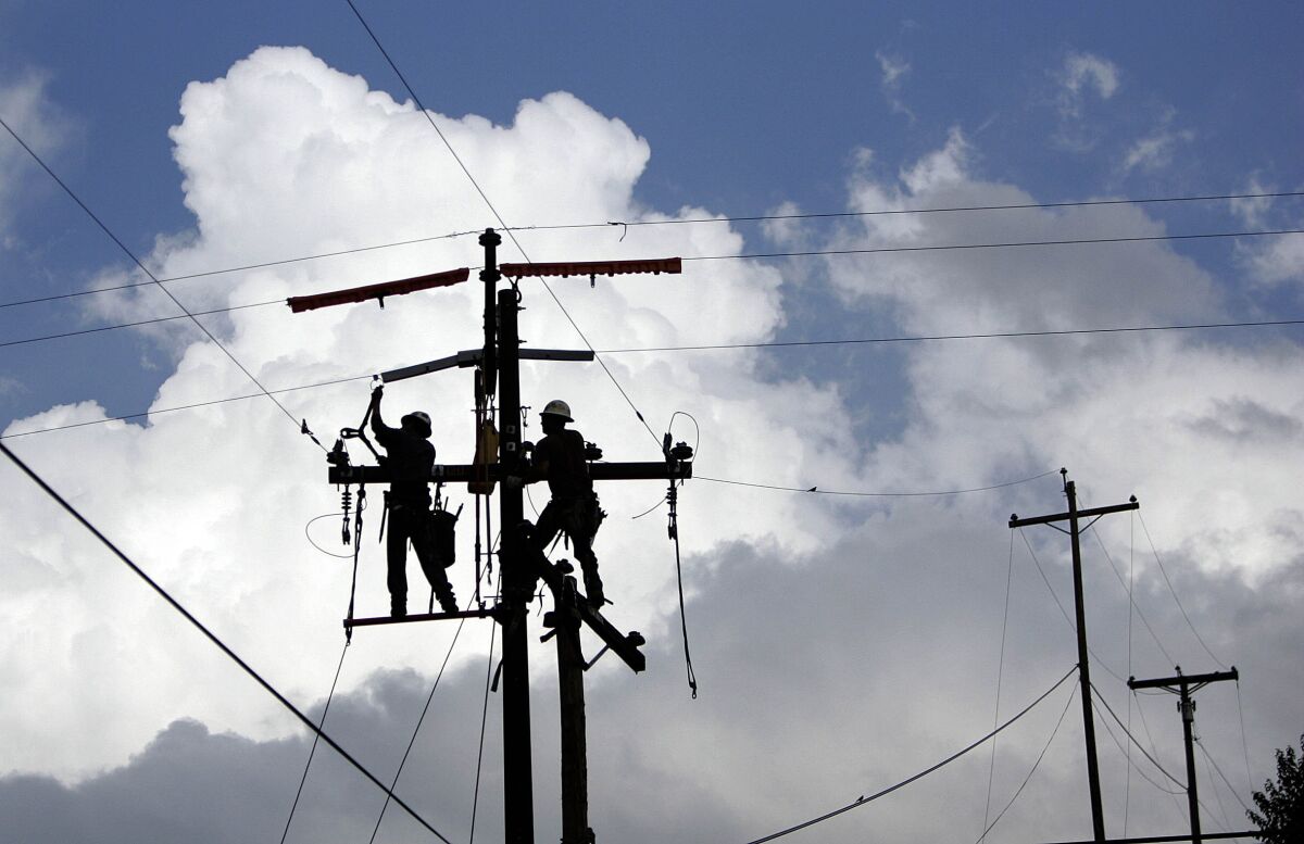 Power lineman replace a wooden power pole carrying 12,000 volts with a steel one in 2011.