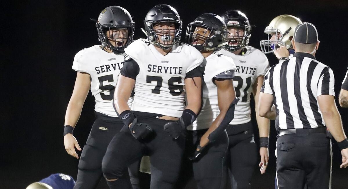 The Servite defense celebrates after a sack of Notre Dame quarterback Zachary Siskowic during the final series of the game as the Friars win, 16-13, in Sherman Oaks on Friday.